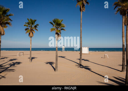 Empty Gandia, Spain beach with palm trees on nice winter day Stock Photo