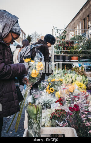 London, UK - February 3, 2019: People buying flowers from a market stalls at Columbia Road Flower Market, a street market in East London that is open  Stock Photo