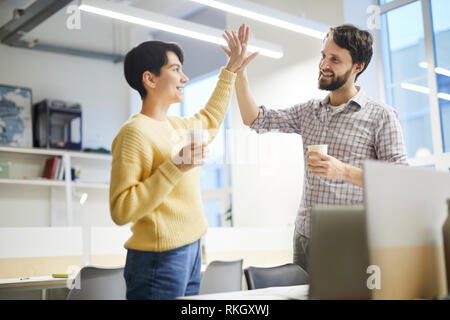Excited colleagues giving high five Stock Photo