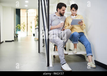 Modern colleagues analyzing online data on tablet Stock Photo