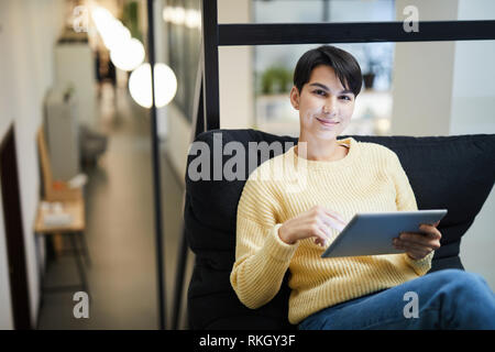 Pretty lady using tablet in cozy office Stock Photo