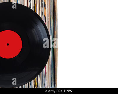 Black record with red label and pile of many close standing vinyl records in old color covers on left side on photo over white background studio shot Stock Photo