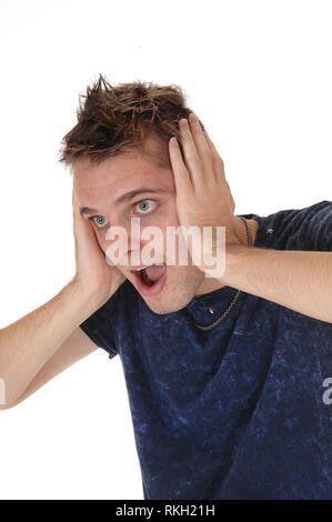 A close up image of a young man standing and screaming with both hand on his head and is scared, isolated for white background Stock Photo