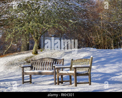 Two snow covered Benches in the grounds of St Ninian's Scottish Episcopal Church, Glen Urquhart, Highland, Scotland Stock Photo