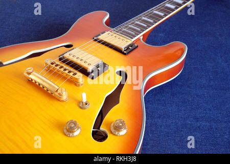 Part of vintage semi-hollow body electric guitars with pickups, electronics knobs and metal accessories on jeans background closeup Stock Photo