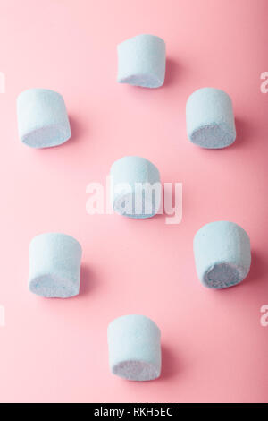 Pattern of blue marshmallows on plain pink background Stock Photo