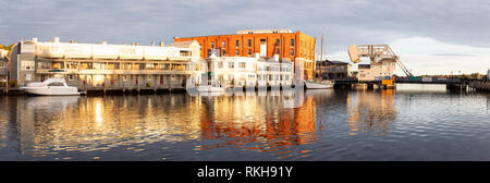 Mystic, Stonington, Connecticut, United States - October 26, 2018: Panoramic view of old historic homes by the Mystic River during a vibrant sunrise. Stock Photo