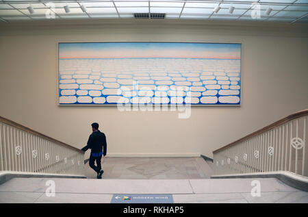 A visitor walking pass by Georgia O'Keeffe's Sky above Clouds IV display in Art Institute of Chicago.Chicago.Illinois.USA Stock Photo