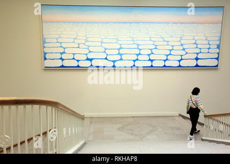 A visitor walking pass by Georgia O'Keeffe's Sky above Clouds IV display in Art Institute of Chicago.Chicago.Illinois.USA Stock Photo