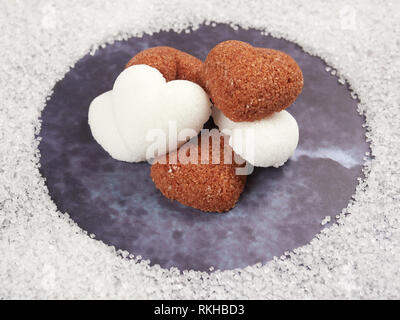 White and brown heart shaped sugar cubes, on blue background Stock Photo