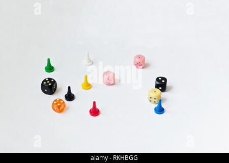 Game pieces of different colors and dice for Board game isolated on a white background. Stock Photo