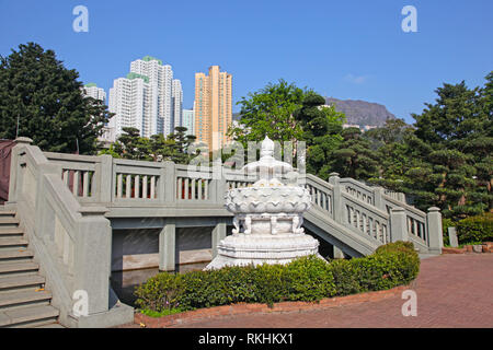 White lotus flower fountain in Nan Lian Garden near Chi Lin Nunnery with city skyscrappers in the background, Hong Kong . Stock Photo