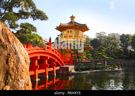 The Golden pavilion and red bridge at sunrise, in Nan Lian Garden near Chi Lin Nunnery, famous landmarks in Hong Kong . Stock Photo