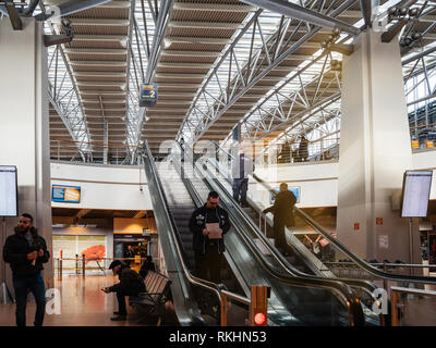 HAMBURG, GERMANY - MAR 20, 2018: People and security officer ascending upper floor of Hamburg Airport Terminal Stock Photo