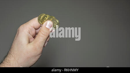 Golden metal coins in a man's hand arranged next to each other Stock Photo