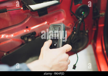 Mechanic installing car central door lock motor Stock Photo