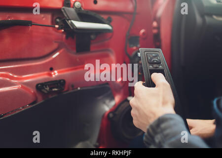 Mechanic installing car central door lock motor Stock Photo