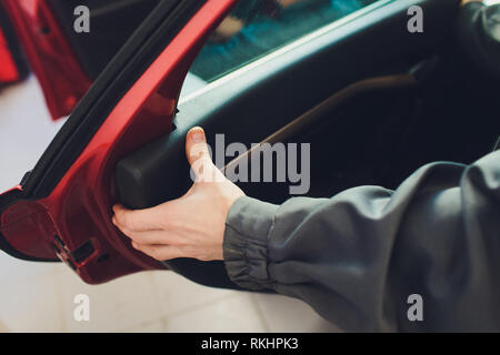 Mechanic installing car central door lock motor Stock Photo