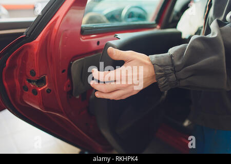 Mechanic installing car central door lock motor Stock Photo