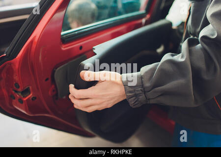 Mechanic installing car central door lock motor Stock Photo