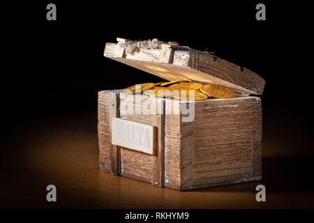 Shiny gold coins (Austrian ducats) in a small wooden treasure box Stock Photo