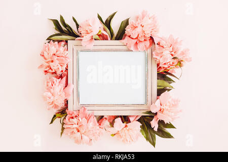 Pastel wooden frame decorated with coral peonies flowers, empty space for text Stock Photo