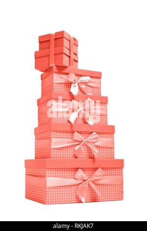 stack of coral gift boxes with satin ribbons on white background. Stock Photo