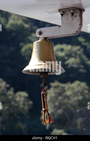 copper bell on a yacht on the background of the coastline Stock Photo