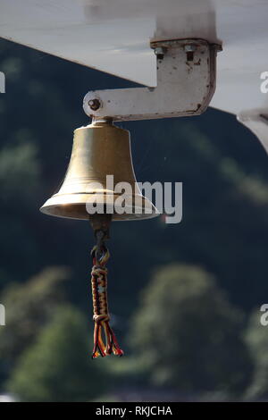 copper bell on a yacht on the background of the coastline Stock Photo