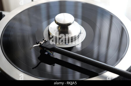 Graphite tonearm of vintage turntable with LP record close up view Stock Photo