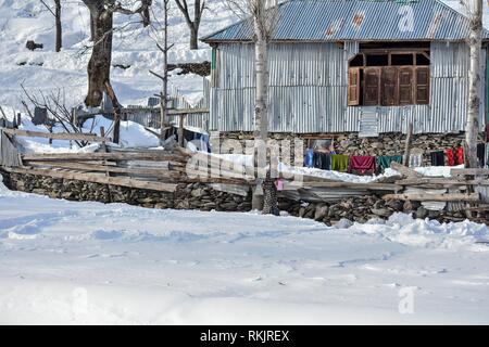 February 11, 2019 - Kashmir, J&K, India - A boy seen holding a jug of water as he walks through a snow covered field during a sunny winter day on the outskirts of Srinagar, Indian administered Kashmir.Weather in the Kashmir valley has shown improvement after the heaviest snowfall. The main National Highway that connects the valley with the rest of the country remained closed for the sixth consecutive day following an avalanche killing seven people including the three policemen, the two firefighters and the two prisoners. The weather man has forecast heavy rain and snowfall from Feb 13. (Credi Stock Photo