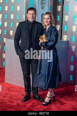 Jason Isaacs and Emma Hewitt attends the EE British Academy Film Awards at the Royal Albert Hall, London. Stock Photo