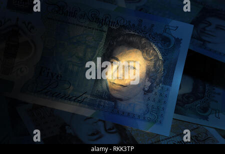 BRITISH FIVE POUND NOTE WITH OTHER BANKNOTES RE MONEY THE ECONOMY THE QUEEN CHURCHILL CASH INCOMES WAGES LOANS ETC UK Stock Photo