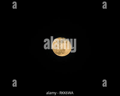 Detailed photo through telescope of waning gibbous moon phase yellow moon Stock Photo