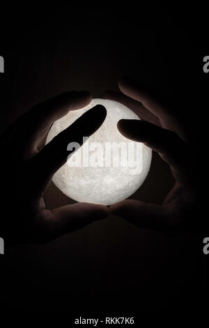 Small moon light in mans hands Stock Photo