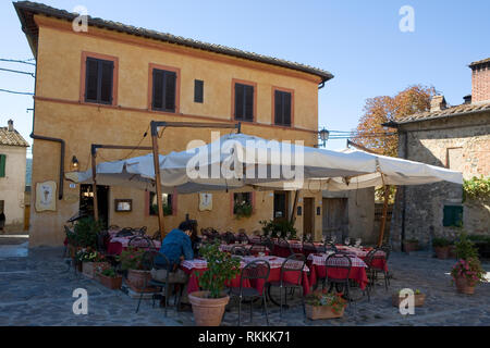 A lone customer awaits service on the terrace of Restaurant - Bar Il Feudo in the main square, Piazza Roma, Monteriggioni, Tuscany, Italy Stock Photo