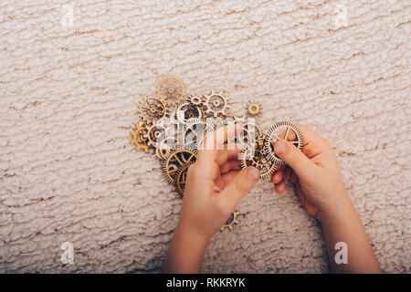 Hand holding gear wheels as the concept of mechanism Stock Photo