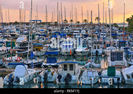 Stunning view of luxury yachts at the pier against the sunset. Yachts and boats anchored in marina. Stock Photo