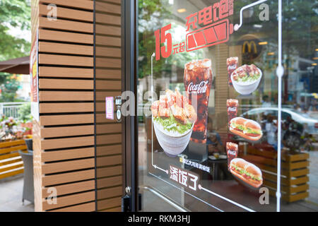 SHENZHEN, CHINA - MAY 06, 2016: a glass door in McDonald's restaurant. McDonald's is the world's largest chain of hamburger fast food restaurants. Stock Photo