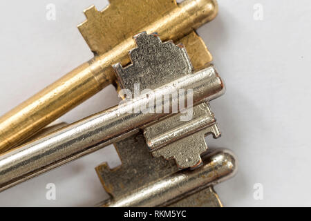 Close-up detail of old metallic keys stainless and yellow isolated on white background. Safety and security concept. Stock Photo