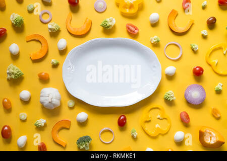 Fresh sliced vegetables on yellow background Stock Photo