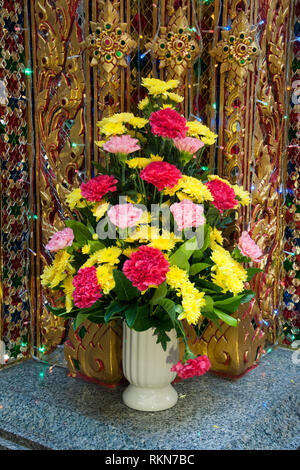 Bangkok Thailand, vase of carnations at Buddhist shrine in the pak khlong talat market Stock Photo