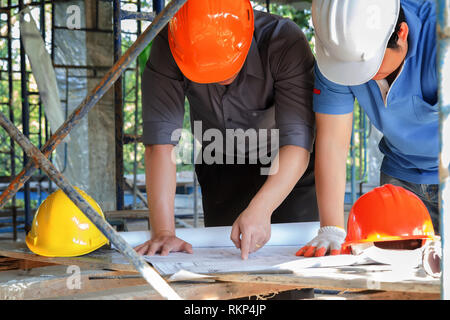 Engineer discussing with foreman about project in building construction site Stock Photo