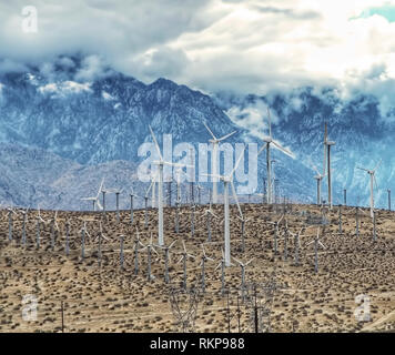 Environmental green power windmills dot a hill in the desert. Stock Photo