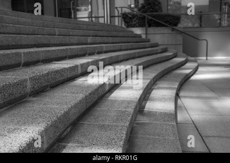 Sweeping Concrete Curved Steps in a city scene, black and white image with long shadows across the steps Stock Photo