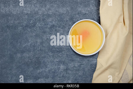 Creative layout made of broth and napkin on grey background. Rich in protein, specifically gelatin and  contain minerals calcium and phosphorus. Stock Photo
