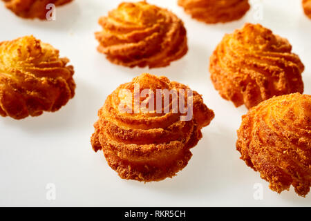 Gourmet fried potato cakes in twirled spirals in a close up view on white for decorative presentation at a formal meal or food styling Stock Photo