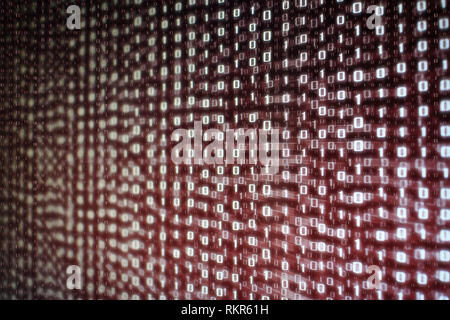 computer data matrix. vertical digital binary code moving motion downward. light up red one and zero text flowing down. black background space with mu Stock Photo