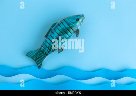Flat lay of fish jumping out of the ocean minimal creative concept. Space for copy. Stock Photo