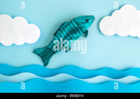 Fish jumping out of sea minimal creative concept. Stock Photo